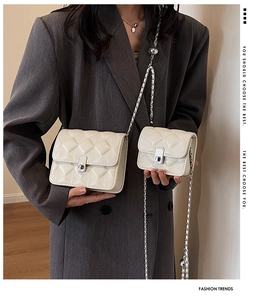 Detail showing white quilted chain bag set in two sizes with metallic silver strap