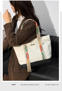 Détail du cabas en toile avec broderie florale colorée sur la large bandoulière d'épaule