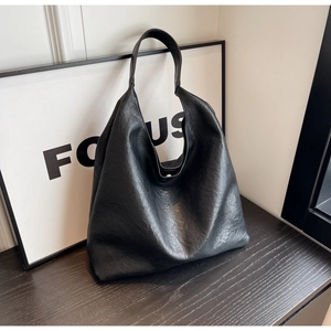 Détail du sac hobo noir avec bandoulière large et fermoir métallique magnétique