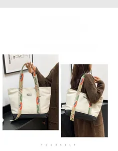 Détail du sac cabas en toile avec bandoulière fleurie et logo de marque brodé