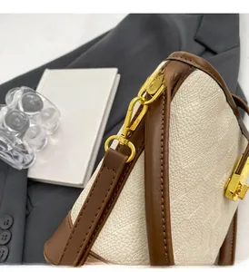 Détail du fermoir tournant doré et des finitions en cuir sur le sac seau rétro