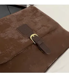 Close-up of vintage dark brown tote bag with textured faux leather and gold metal buckle