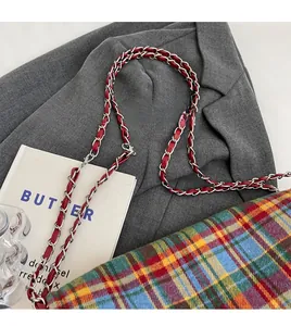 Close-up of multicolor plaid tweed tote with red leather interwoven chain strap detail