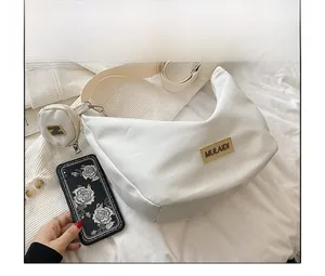 Détail du sac croissant en nylon blanc avec mini pochette ronde et logo MULAIDI