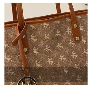 Détail macro du sac cabas marron avec imprimé Pégase et breloque métallique M