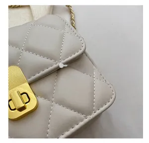 Close-up of beige quilted leather mini bag featuring gold twist lock and precise stitching