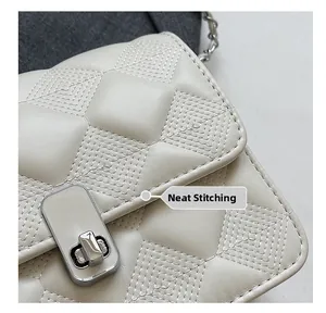 Close-up of white quilted leather bag showing neat stitching and silver twist lock detail