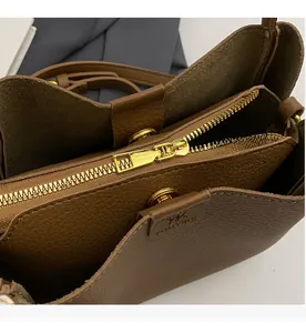 Detail view of smooth golden zipper and brown leather interior of the bucket bag