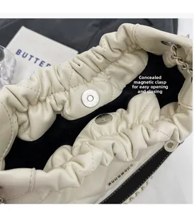 Detail view of cream white cloud bag showing invisible magnetic buckle and chain strap