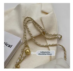 Detail of adjustable golden metal ball on cream quilted chain strap handbag