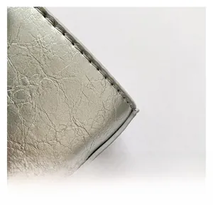 Detail shot of the metallic silver textured fabric with fine white stitching on the bag