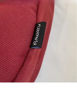 Close-up of BANATU dark red knit fabric texture with a black woven side label detail