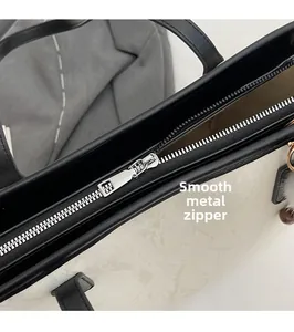 Detailed close-up of the smooth metal zipper and secure top closure on the tote bag