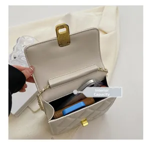 Internal capacity of white quilted chain bag showing space for phone and makeup