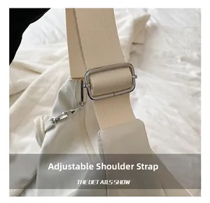Vue détaillée de la bandoulière réglable avec boucle en métal argenté sur un sac beige