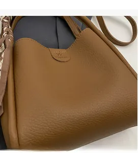 Detail of brown litchi pattern leather handbag featuring decorative printed scarf handle