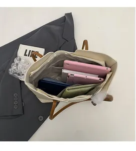 Interior view of beige tote bag with multi-compartment dividers for laptop and wallet