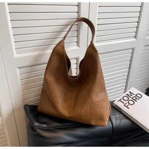 Détails de texture du sac hobo en similicuir marron sur un coussin élégant