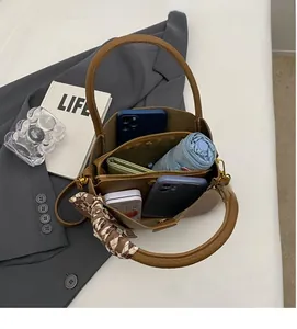 Macro view showing the large interior capacity of this brown leather bucket handbag