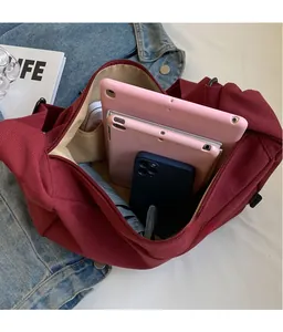 Detail view of large burgundy corduroy hobo bag showing spacious interior for tablets
