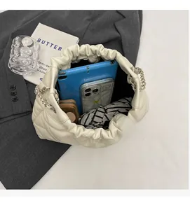 Overhead view showing large interior capacity of a white quilted chain bucket bag