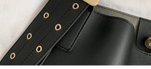 Détails rapprochés de la bandoulière en cuir noir avec œillets dorés et coutures précises