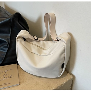 Detailed texture of off-white corduroy hobo bag with adjustable strap on stone base