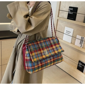 Close-up of tartan plaid tote bag with silver chain strap and red leather side panel