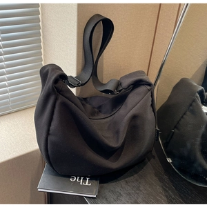Detail of a black canvas crossbody bag showing durable twill texture and minimalist design