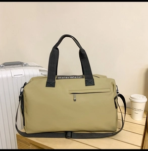 Gros plan du sac de voyage en tissu Oxford kaki avec poche zippée et logo de marque