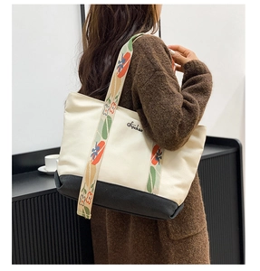 Détail du sac cabas en toile avec base contrastée et bandoulière à fleurs brodées