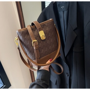 Détail du sac seau matelassé marron foncé avec fermoir doré et texture en similicuir