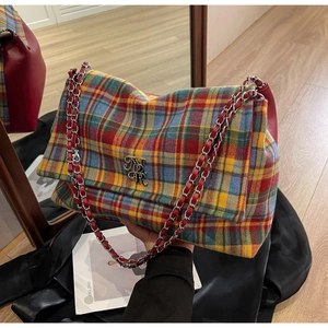 Detail of multi-color tweed plaid shoulder bag with silver chain and vintage buckle