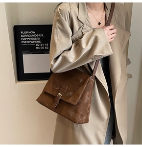 Close-up of brown frosted leather tote bag showing vintage texture and strap detail