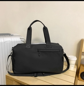 Détail d'un sac de voyage noir en tissu Oxford imperméable avec fermeture éclair avant