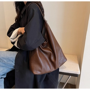 Gros plan sur le sac fourre-tout en cuir grainé marron caramel avec une large bandoulière