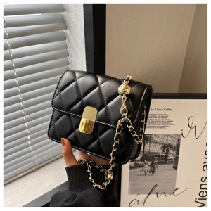 Detailed close-up of a black quilted crossbody bag with a golden chain and twist lock