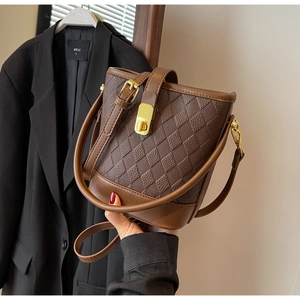 Détail du sac seau matelassé marron avec fermoir doré et poignée ronde rigide