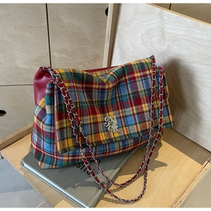 Detail of multi-color plaid tote bag with silver NR logo and metal chain strap