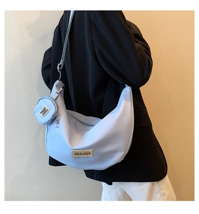 Gros plan du sac à bandoulière bleu clair avec porte-monnaie et détails métalliques