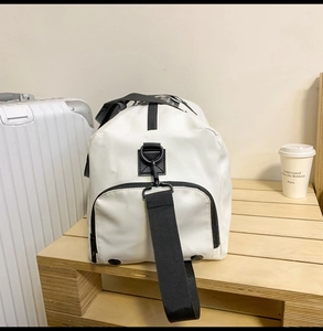Gros plan d'un sac de sport en toile blanche avec sangles noires et poche latérale zippée