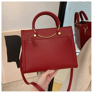 Close-up of red pebbled leather bridal handbag with gold hardware and top handle