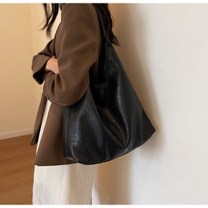 Détail du grand sac cabas noir montrant la texture du cuir et son intérieur spacieux