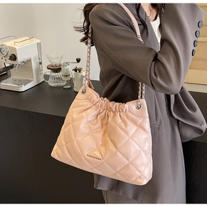 Detail of light pink quilted bucket bag with chain strap and metallic brand logo