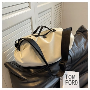 Detailed view of white Oxford cloth crossbody bag with black straps and soft texture