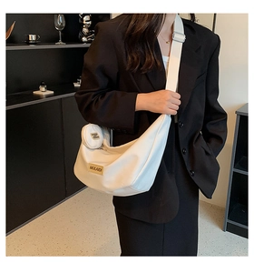 Gros plan sur le sac demi-lune blanc avec bandoulière large et mini porte-monnaie