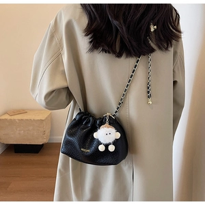 Detail of black pleated cloud bag with chain strap and cute white sheep charm