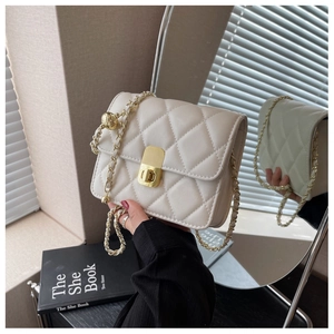 Detail of white quilted crossbody bag with golden chain strap and metallic square lock