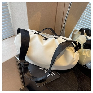 Macro detail of white water-resistant oxford fabric dumpling bag with black nylon straps