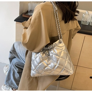 Detail of silver quilted bucket bag featuring a woven chain strap and HOROMORD logo